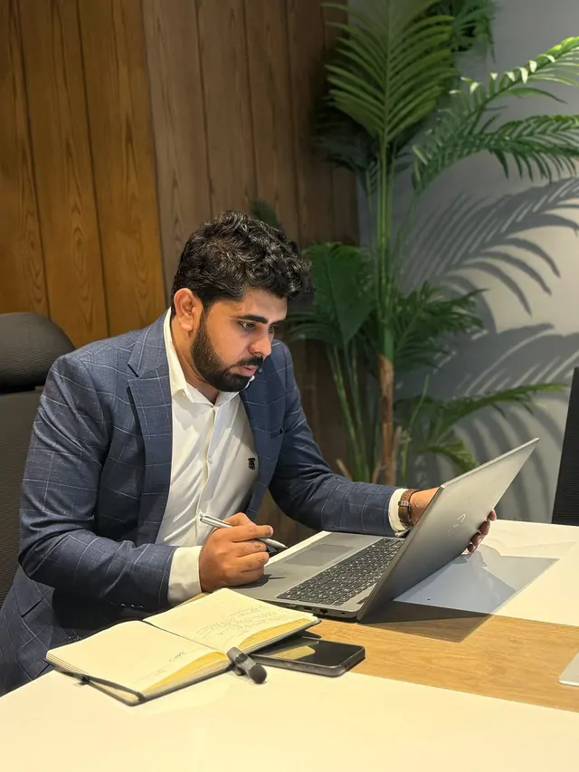 Hafiz Muhammad Farhan reviewing architecture notes on a laptop