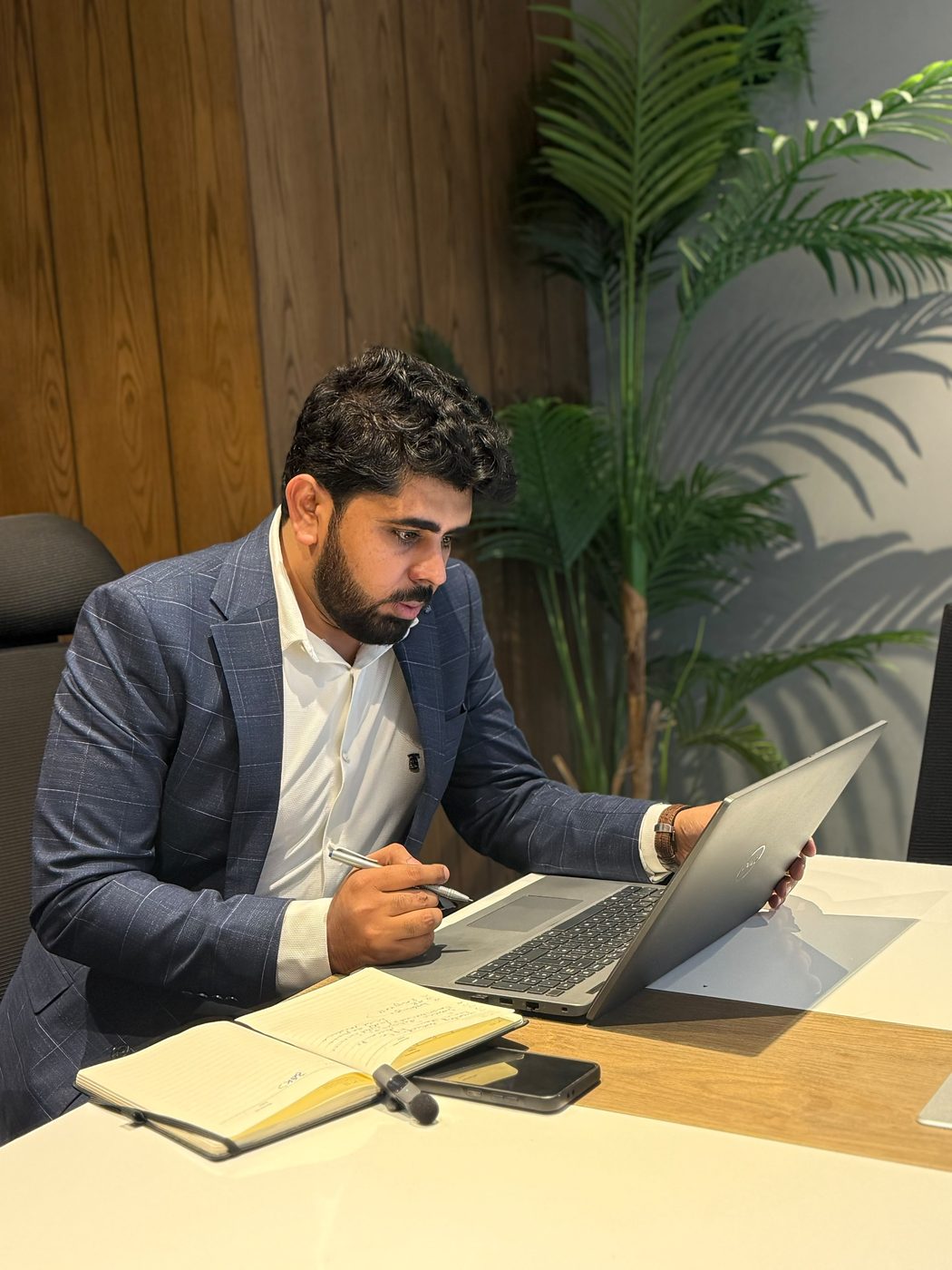 Hafiz Muhammad Farhan reviewing architecture notes on a laptop